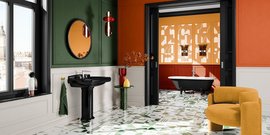 Ein stilvolles Badezimmer mit einer schwarzen Waschbeckenanlage und einem eleganten, runden Spiegel an einer grünen Wand.