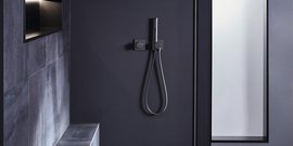 Ein modernes Badezimmer mit einer eleganten schwarzen Duscharmatur und einer minimalistischen Wandgestaltung.