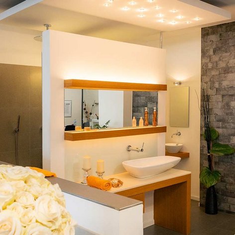 Ein modernes Badezimmer mit einer eleganten Badewanne, einem großen Spiegel und stilvollen Pflanzen im Hintergrund.