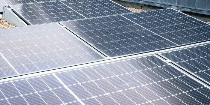Eine große Fläche mit Solarpanelen, die in einem modernen Gebäude installiert sind, reflektiert das Sonnenlicht.