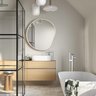 Ein modernes Badezimmer mit einer eleganten Dusche, einem freistehenden Bad und einem großen runden Spiegel an der Wand.