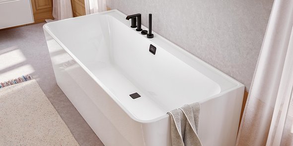 Eine moderne, weiße Badewanne mit eleganten schwarzen Armaturen und einem Handtuch, das über die Seite hängt.