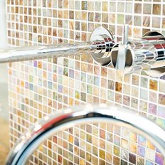Ein glänzender Wasserhahn aus Chrom, der an einer bunten Mosaikwand montiert ist, strahlt modernes Design aus.