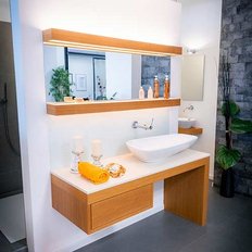 Ein modernes Badezimmer mit einem eleganten Waschbecken, Holzregalen und dekorativen Elementen, die eine entspannende Atmosphäre schaffen.