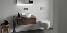 Ein modernes Badezimmer mit einem schwebenden Holzwaschtisch und einer runden Waschschüssel, die elegant in Szene gesetzt ist.